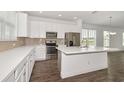 Well-lit kitchen with white cabinetry, stainless steel appliances, and a functional center island at 6633 Calamondin Dr, Winter Garden, FL 34787