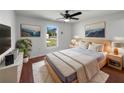 Bright bedroom features a ceiling fan, wood floors, and beach-themed wall art at 760 Park Ave, Orange City, FL 32763