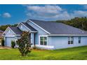 This beautiful blue home features a well manicured lawn and dark roof at 7732 Sloewood Dr, Leesburg, FL 34748