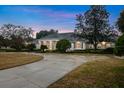 Sprawling single story home with a circular driveway and well-maintained landscaping and mature trees at 1080 Edmiston Pl, Longwood, FL 32779