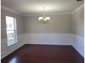 Formal dining room featuring classic wainscoting, crown molding, and gleaming hardwood floors at 115 Royalty Cir, Sanford, FL 32771