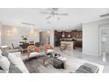 Bright, open-concept living room featuring modern decor and an elegant chandelier above the living room and dining area at 2224 Romanum Dr, Winter Garden, FL 34787