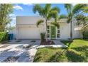 Inviting exterior featuring a modern design, manicured lawn, palm trees, and a two-car garage at 2411 Center Ave, Orlando, FL 32806