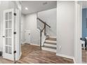 Bright foyer featuring hardwood floors, staircase with modern railing, and a view into other rooms at 4622 Eureka Ln, Sanford, FL 32773