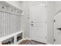 Practical mudroom featuring a built-in bench with storage and coat hooks for organization and convenience at 4622 Eureka Ln, Sanford, FL 32773