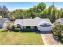 Expansive aerial view showcasing the property's mature landscaping, neutral color palette, and attached two-car garage at 7646 Covedale Dr, Orlando, FL 32818