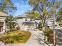 Two-story home with attached garage, mature trees, and a curving driveway at 8380 Baywood Vista Dr, Orlando, FL 32810