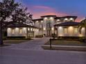 Twilight view of a modern two-story home featuring elegant lighting and manicured landscaping at 8521 Lake Nona Shore Dr, Orlando, FL 32827