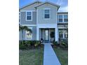 Charming townhome featuring a covered porch and manicured landscaping at 11038 Leafshore Loop, Orlando, FL 32829