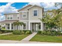 Inviting two-story townhome with a quaint front porch and lush, green landscaping at 11038 Leafshore Loop, Orlando, FL 32829
