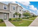 Well-kept townhome showcasing manicured lawn and tidy landscaping under a blue sky at 11038 Leafshore Loop, Orlando, FL 32829