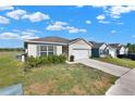 Well-kept single story house with muted color scheme, green shutters, and a two car garage at 11207 Amber Ridge Dr, Zellwood, FL 32798