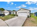 Single story home with a muted color scheme, well kept lawn, and a two car garage at 11207 Amber Ridge Dr, Zellwood, FL 32798