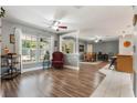 Open-concept living area featuring hardwood floors, lots of light, and open sightlines to the kitchen at 115 Shepherd Trl, Longwood, FL 32750