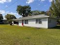 Well-maintained home with a bright red door and lush green lawn at 143 Louisiana Ave, St Cloud, FL 34769