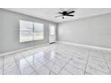 Bright living room with white tiled floors, ceiling fan and neutral paint at 143 Louisiana Ave, St Cloud, FL 34769