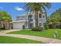 Charming two-story home with a well-manicured lawn, beautiful landscaping, and a large palm tree at 1923 Osman Ave, Orlando, FL 32806