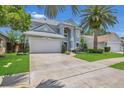 Charming two-story home with a well-manicured lawn, beautiful landscaping, and a large palm tree at 1923 Osman Ave, Orlando, FL 32806