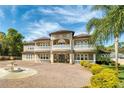 Elegant two-story home featuring a grand facade, a circular driveway, and a beautifully landscaped yard at 1984 Windermere Rd, Windermere, FL 34786