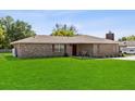 Classic brick home with lush green lawn and mature trees in a quiet neighborhood setting at 2010 Overlook Dr, Winter Haven, FL 33884