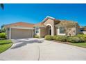 Beautiful home featuring a two-car garage, a curved driveway and lush landscaping at 2721 University Acres Dr, Orlando, FL 32817