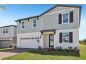 Two-story home with a combination of vertical and horizontal siding, a brick driveway, and an attached garage at 312 Castle Dr, Lake Alfred, FL 33850