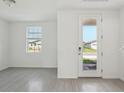 Bright, neutral living room with tile flooring, a large window, and a glass front door at 312 Castle Dr, Lake Alfred, FL 33850