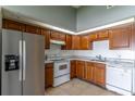 Traditional kitchen with wood cabinets, white appliances, and tile flooring at 3143 Stonecastle Rd, Orlando, FL 32822