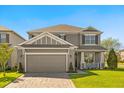 Beautiful two-story gray home boasts lush landscaping and an inviting front porch at 432 Treasure Ln, Sanford, FL 32771