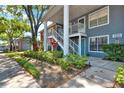 Landscaped condo building featuring staircases, foliage, and blue siding at 5429 Lake Margaret Dr # E, Orlando, FL 32812