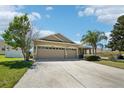 Charming single-story home features a three-car garage, manicured lawn, and mature landscaping at 5832 Tarleton Way, Mount Dora, FL 32757