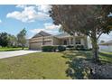 Single-story home with manicured lawn and a three-car garage offers great curb appeal at 5832 Tarleton Way, Mount Dora, FL 32757