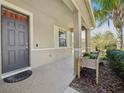 Inviting front porch with brick flooring and a stylish front door, complemented by greenery at 5832 Tarleton Way, Mount Dora, FL 32757