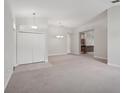 Spacious living room with neutral carpeting, complemented by a view of the kitchen at 5832 Tarleton Way, Mount Dora, FL 32757