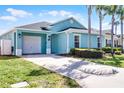 Beautiful single-story home featuring a lush green lawn, landscaping, and attached garage at 631 Reserve Dr, Davenport, FL 33896