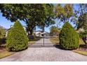 Gated driveway leads to an elegant home surrounded by mature landscaping at 7841 Georgeann St, Winter Park, FL 32792