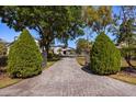 Long, gated brick driveway leading to a modern two-story home with mature trees and manicured landscaping at 7841 Georgeann St, Winter Park, FL 32792
