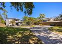 Lush landscaping and a circular driveway complement the modern exterior of this two-story home with a grey brick driveway at 7841 Georgeann St, Winter Park, FL 32792