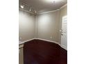 Inviting living room with dark wood-look floors, a door to the right and track lighting illuminating the neutral walls at 860 N Orange Ave # 149, Orlando, FL 32801