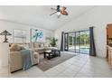 Bright living room with tile flooring, a ceiling fan, and sliding glass doors to the pool at 1120 Parker Canal Ct, Oviedo, FL 32765