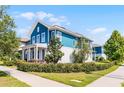 Corner lot featuring a blue two-story home with pristine landscaping, and a sidewalk at 13087 Salk Way, Orlando, FL 32827