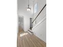 Bright entry with soaring ceilings, wood-look flooring, staircase, and pendant lighting at 13087 Salk Way, Orlando, FL 32827