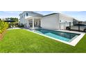 Gorgeous backyard featuring a modern pool, manicured lawn, and outdoor lounge space at 14004 Gullstrand Ave, Orlando, FL 32827