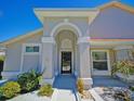 Close-up of the front entrance highlighting the arched entryway, black door, and landscaping at 14901 Wild Wood Lily Ct, Orlando, FL 32824
