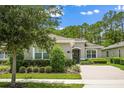 Charming single-story home with manicured landscaping, a brick driveway, and a neutral color palette under a blue sky at 1686 Victoria Gardens Dr, Deland, FL 32724