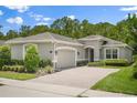 Charming single-story home featuring a brick driveway, two-car garage, manicured landscaping, and a neutral color palette at 1686 Victoria Gardens Dr, Deland, FL 32724