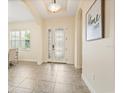 Bright foyer featuring tile flooring, an ornate front door, and arched doorways, offering a welcoming entrance at 1686 Victoria Gardens Dr, Deland, FL 32724