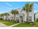 Modern two-story townhomes boasting pristine landscaping, stone accents, and decorative palm trees lining the sidewalk at 17522 Hidden Forest Dr, Clermont, FL 34714