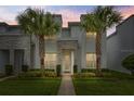 Beautiful two-story home featuring stone accents, well-manicured lawn, and decorative palm trees against an evening sky at 17522 Hidden Forest Dr, Clermont, FL 34714