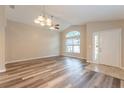 Bright and airy living room with vaulted ceilings, stylish wood flooring, and a large arched window at 2104 Remington Pointe Blvd, Kissimmee, FL 34743